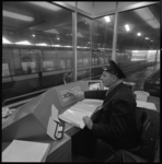 10565-2 Man bedient apparatuur in controlepost in metrostation Zuidplein.