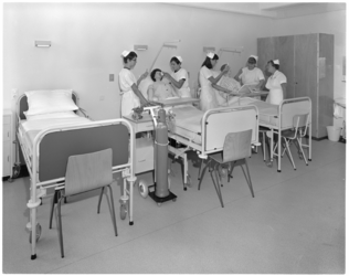 10859-3 Oefenruimte met verpleegkundigen, patiëntpoppen en drie bedden.