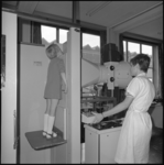 10898-2 Een meisje en een verpleegkundige tijdens een longonderzoek.