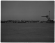 11191 Foto van houten gebouwen, onder andere van de Havendienst Luchthaven Rotterdam; en staartgedeelte van vliegtuig, ...