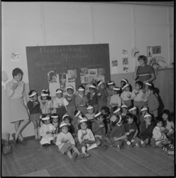 11225 Groepsfoto van Ambonese kinderen met hun begeleidsters in de kleuterschool van het houten barakkenkamp ...