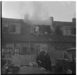 1185 Brandweerlieden op het schuine dak van rokende zolderetage aan de Heerjansweg in de wijk Bloemhof.
