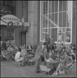 11872 Mensen zitten op terras van Noordzee-Quick-restaurant bij een ingang van het Beursgebouw op het Beursplein.