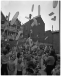 11919 Kinderen laten ballonnen van het Rotterdams Nieuwsblad op, temidden van huizen en achtertuinen.