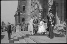 1346-8 Koningin Juliana krijgt bij aankomst op het stadhuis bloemen aangeboden; in het midden koningin Elisabeth II en ...