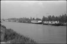 1662-1 Rij achter elkaar liggende woonboten in het Noorderkanaal; naast hen het campingterreinaan de Kanaalweg.