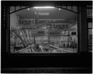 1860-7 Etalage van kruidenierswinkel 'de Coöperatie' met uitstalling van zuivelproducten.