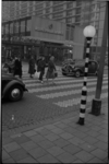 1880 Overstekende voetgangers op een zebrapad in de Karel Doormanstraat, bij de Korte Lijnbaan; midden: de muziekwinkel ...
