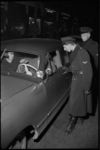 1992 Twee politiemannen in gesprek met de bestuurder van een personenauto tijdens een verkeerscontrole.