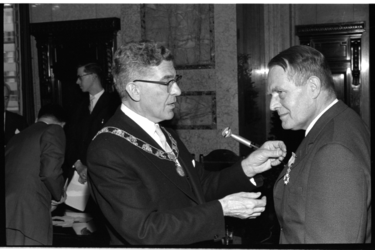 20025-82-12 Wethouder mr. H. Bavinck ontvangt koninklijke onderscheiding, opgespeld door burgemeester Wim Thomassen.
