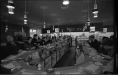 20036-20-13 In Hema-restaurant tafels in hoefijzeropstelling; gasten lopen langs de uitgestalde etenswaren.