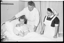 2070 Baby Lena Martina met moeder Verveer-Kooiman uit Barendrecht, met dokter P. Dros en zuster H. Popken die bij de ...