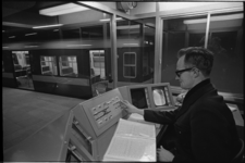 20741-5-18 Toezichthouder zit voor controlepaneel op het perron van metrostation Beurs.