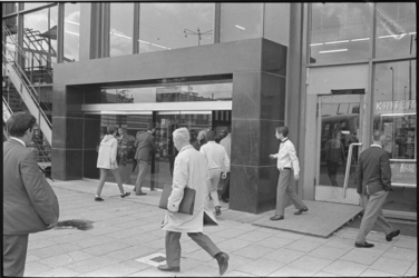 21032-7-40 Voetgangers rond de vernieuwde ingang van het Groot Handelsgebouw, zijde Stationsplein.