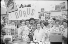21126-1-38 In een vestiging van de supermarktketen Spar signeert Tom Manders (Dorus), hier omringd door het personeel, ...