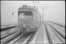 21247-7-40 Een met bloemen versierde tram van lijn 5 rijdt op het nieuwe tramviaduct Schiebroek-Schieweg, boven de ...