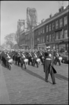 21289-5-24 Marinierskapel marcheert door de Rosestraat in de wijk Feijenoord; op de achtergrond de Hefbrug.