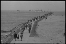 21365-2-29 Wandelende mensen op de Grote Pier, het Noorderhoofd van Hoek van Holland tussen strand en Nieuwe Waterweg.