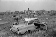 21428-7-32 Kinderen spelen op autowrak op een veldje aan de Lieven de Keystraat in het Lage Land (Prins Alexander).