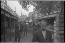 21463-5-7 Mensen lopen tussen de stalletjes op de groente- en fruitmarkt aan het Noordplein.