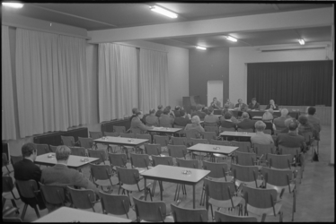 21617-4-1 Een zaal met mensen en aantal lege tafels en stoelen tijdens de oprichtingsvergadering van het 'Comité ...