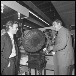 22071-4-6 Willem Duys (rechts) plaatst de naald op een ouderwetse grammofoonplaat-installatie; Disk-directeur Lou Thiel ...