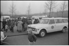 22952-3-30 Politie begeleidt Italiaanse zigeuners de stad uit. Op de voorgrond een Chevrolet C-10 patrouillewagen. Zij ...