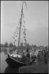 23391-7-38 Gepavoiseerd schip 'De Drie Joffers' wordt opgewacht door aantal mensen die op de wal van de Bergse Linker ...