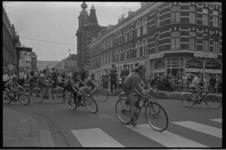 23619-1-10A Wielrenners rijden vanuit de Noordmolenstraat rechtsaf de Jacob Catsstraat in. Op de achtergrond de Noorderkerk.