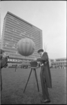 23847-4-17 Fotograaf, met platencamera op statief en kleinbeeldcamera aan de schouder, maakt foto van de gasballon ...
