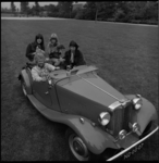 24992-3-9 Striptekenaar Jan Kruis en zijn gezin en huisdieren in een antieke MG sportauto.