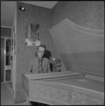 25144-1-3 Organist en koordirigent Aad van der Hoeven achter een klavecimbel. Op de achtergrond een interieurfoto van ...