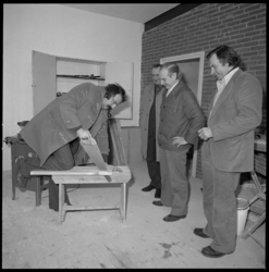 25231-3-5 Burgemeester André van der Louw neemt tijdens een bezoek aan de wijk Feijenoord-Noordereiland een zaag ter ...