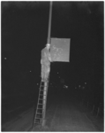 265-1 Man op ladder bij lichtmast en onherkenbaar reclamebord door roetaanslag.