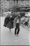 304918-8 Twee mensen lopen op de Binnenweg; richting Karel Doormanstraat en sjouwen met een opgerold tapijt tijdens de ...