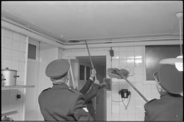305595-30 Politieagenten 'jagen' op een rat in de kelder van de kraaminrichting Carmenta aan de Heemraadssingel 119.