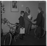 3268 Hoofdcommissaris H.M.C.A. Staal reikt fietsen uit aan twee Rotterdamse jongens i.v.m. hun behaalde verkeersexamen.