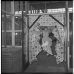 3371-12 Met een sprong door een muur van kranten opent de 13-jarige Liesbeth Kuiper 'Jeugdland 1959' in de Energiehal.