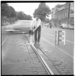 3408 Op -door de hitte- uitgezette tramrails giet een man op de Mathenesserlaan water in de tramrails.