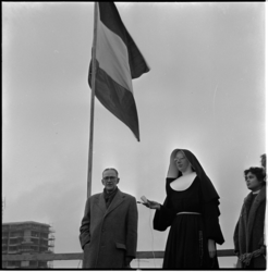 347 Vlag in top bij het hoogste punt van de bouw van de rooms-katholieke kweekschool aan de Aert van Nesstraat. In het ...