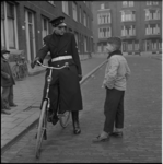 403-3 Een agent op een fiets spreekt een jongen toe.