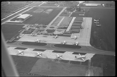 4060-1 Drukte door geparkeerde vliegtuigen op luchtfoto van het platform van Luchthaven Rotterdam.