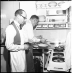 4072-1 Mannen met schorten aan het (keuken)werk op een zuivelbeurs.
