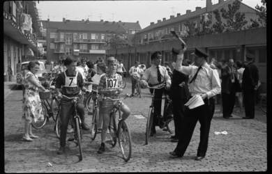4247-1 Politieman geeft het startsein voor een -fiets-puzzelrit voor de jeugd in Schiebroek.