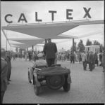 4260-1 Staande in een old-timer opent wethouder H. Bavinck het nieuwe Caltex tankstation aan de Stadhoudersweg in Blijdorp.