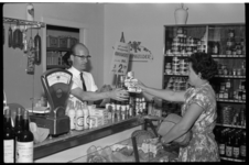 4475-2 Kruidenierswinkel met winkelier en huisvrouw die ('gewone' Bleu Band) margarine koopt.