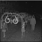 4520-1 Kinderen lopen met grote beeldmerkborden van de Floriade tijdens een lampionoptocht.