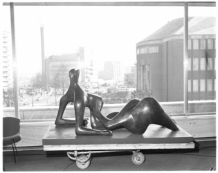 455-3 Sculptuur Reclining Figure van Henry Moore op een transportkarretje in de lunchroom 1e etage van de nieuwe Bijenkorf.