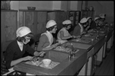 4892-1 Witgemutste leerlingen van de huishoudschool. proeven de door henzelf bereide maaltijden tijdens praktijklessen ...