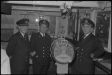 5098 Drie geüniformeerde zeelieden op de commandobrug van ms.'Willem Ruys' staan rond de telegraaf.